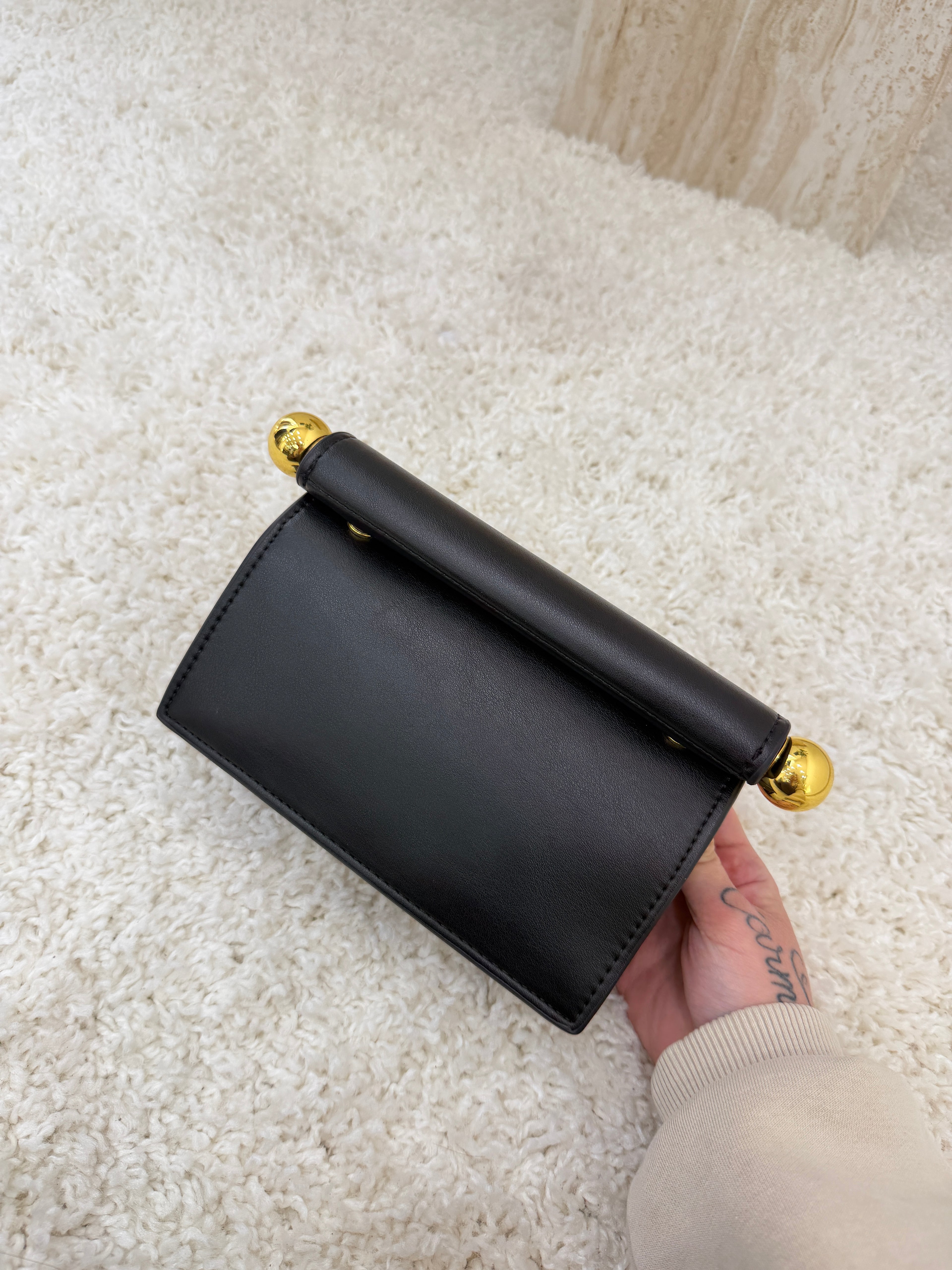 Borsa clutch nera con dettagli a sfera oro